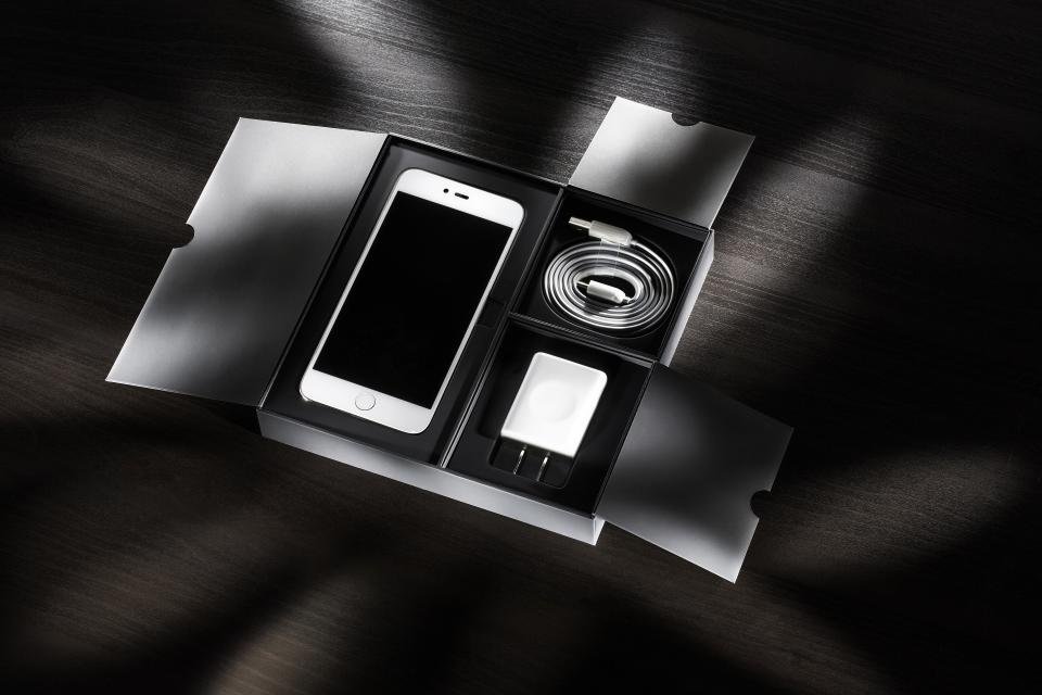 Smartphone dentro da caixa, com cabo e carregador, ilustrando um produto recém-comprado